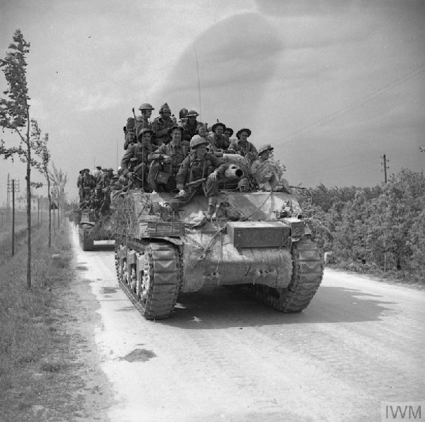 Men of the 2nd Lancashire Fusiliers are carried forward on Sherman tanks near Ferrara, 22 April 1945.