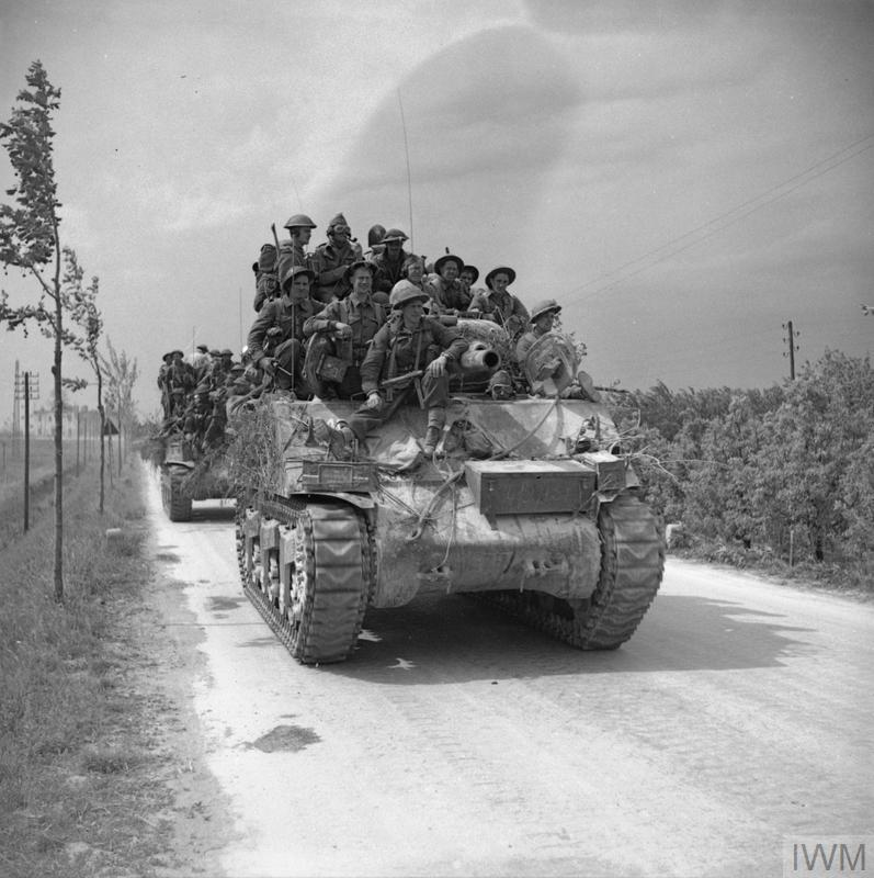 Men of the 2nd Lancashire Fusiliers are carried forward on Sherman tanks near Ferrara, 22 April 1945.